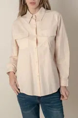 Camisa blanca de manga larga con dos bolsillos frontales con solapa.