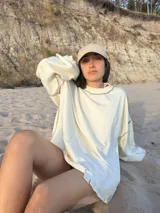 Buzo deportivo color crudo con costuras overlock visibles en color marrón.