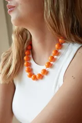 Collar de cuentas esféricas de acrílico color naranja brillante, con cierre ajustable.