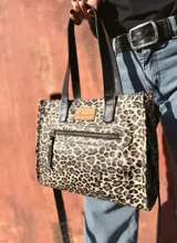 Cartera bandolera Shill Mini de cuero con estampado animal print, forro de tela y correa larga negra regulable. Cuenta con bolsillo frontal con cierre y bolsillo interno. Fabricación nacional.