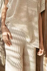 Pantalón de tiro alto, color crudo, tejido con hilo de algodón en punto pavo real y corte holgado.