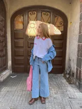 Jean azul claro de corte acampanado con ruedo deshilachado.