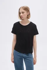 Remera negra de mangas cortas con cuello redondo y pequeños apliques metálicos en el frente.