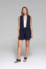 Chaleco azul marino con finas rayas verticales blancas, sin mangas, con solapas y bolsillos frontales.