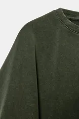 Camiseta blanca de manga corta con corte oversize y cuello redondo. El diseño presenta mangas amplias tipo capa que caen desde el hombro.