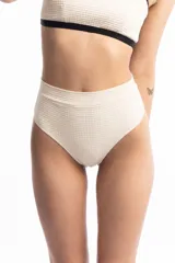 Bombacha de bikini color crudo, de tiro alto y lycra doble en la faja.