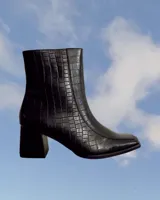 Bota de cuero color marrón con tacón cuadrado y diseño elegante.