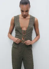 Top verde oliva de tejido texturizado, con cuello en V y cierre frontal con lazos.