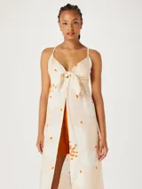 Musculosa femenina tipo túnica color naranja con estampado abstracto en blanco y marrón.