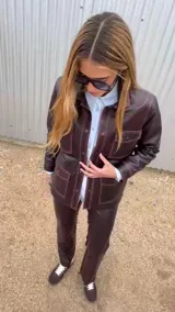 Chaqueta de cuero ovino color verde gastado, con cuello clásico, cierre frontal con botones, múltiples bolsillos con solapa y costuras a la vista.