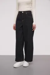 Pantalón de jean negro con rayas verticales, de corte holgado y pierna ancha.