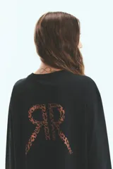 Remerón oversize de algodón negro con cuello redondo y estampa en la espalda, de manga larga.