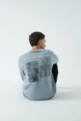 Remera celeste de manga larga con cuello redondo y estampado frontal con texto "New York NY 10038"