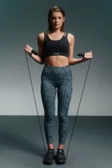 Calza larga deportiva con estampado animal print en tonos de verde y gris.