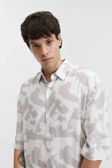 Camisa oversize de manga corta con estampado abstracto en tonos beige y blanco.