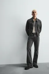 Pantalón de jean negro con efecto lavado, corte bootcut, tiro medio y cinco bolsillos.