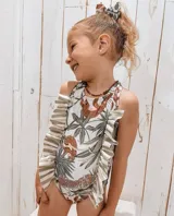 Traje de baño entero blanco con estampado de hojas de palmera, perezosos y un leopardo en la parte inferior. Tiene volados en los laterales.