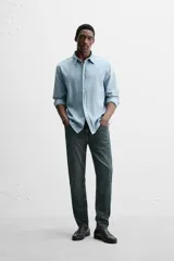 Pantalón de jean azul oscuro, corte slim fit, tiro medio, cinco bolsillos, tejido elástico y efecto lavado.
