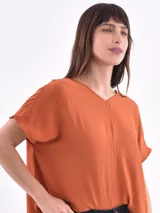 Blusa color verde oliva, de corte holgado, con escote en V y mangas cortas.