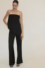 Top bandeau negro de tejido satinado con escote recto y hombros descubiertos. Tiene bandeau interior y cierre lateral con cremallera oculta.