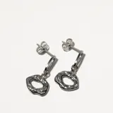 Par de caravanas plateadas con forma irregular y textura martillada.