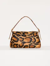 Cartera tipo baguette con estampado animal print de leopardo, confeccionada en cuero con pelo y detalles en cuero vacuno flor. Tiene correa regulable en combinación de cuero y pelo, con hebillas metálicas personalizadas.