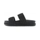 Sandalia plana de mujer con dos tiras anchas sobre el empeine. Las tiras tienen un acabado texturizado que simula tejido o rafia en color beige claro. La plantilla y la suela son del mismo tono neutro y la suela es gruesa con relieve en el borde.