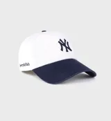 Gorra de béisbol blanca con visera azul marino y logo de los Yankees bordado en azul marino. Confeccionada en sarga de algodón, con cierre ajustable y diseño de seis paneles sin estructura.
