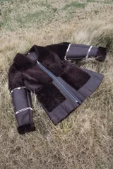 Campera gamulán marrón con cierre frontal, cuello solapa y bolsillos laterales.