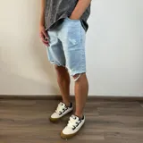 Bermuda de jean celeste con roturas y terminación desflecada.