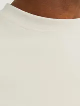 Camiseta de manga corta color beige, con cuello redondo y corte holgado.