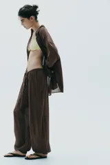 Pantalón bombacho color marrón confeccionado en algodón 100%. Tiro medio con cintura elástica ajustable con cordones y bajo abullonado con elástico.