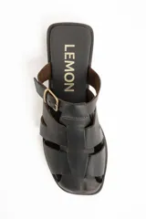 Zueco tipo cangrejera de cuero marrón oscuro, estilo mule (sin talón), con tiras trenzadas en la parte delantera y hebilla ajustable en el empeine.