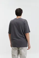 Remera de manga corta color marrón claro, de corte amplio y cuello redondo.