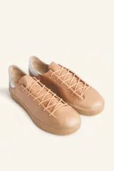 Zapatillas bajas blancas de cuero vacuno con detalle de refuerzo de gamuza color borgoña en el talón y suela de goma color caramelo.
