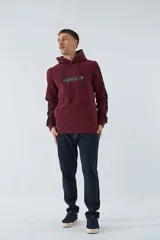 Buzo canguro color bordó con capucha y cordones negros. Tiene mangas largas con una franja vertical azul marino en los laterales y un estampado con texto en el pecho.