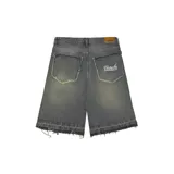 Bermuda de jean gris oscuro con efecto desgastado, corte amplio, largo a la rodilla y ruedo desflecado.