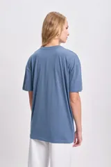 Remera celeste de corte amplio con estampa amarilla con la palabra 'Sunday'.