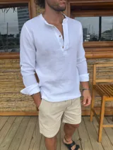 Camisa blanca de muselina, corte slim fit, con cuello mao y mangas largas con botón para enrollar.