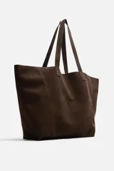 Bolso tipo shopper color marrón claro, fabricado en piel serraje. Cuenta con dos asas de mano y un bolsillo interior con cierre de cremallera.