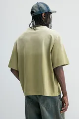 Remera de algodón color verde con efecto desteñido, corte amplio, cuello redondo y mangas cortas.
