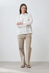 Camisa fucsia de broderie con cuello clásico, cierre frontal con botones y mangas largas.