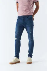 Pantalón de jean skinny azul oscuro con roturas y tiro medio.