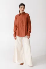 Camisa blanca de lino con botones de madera, corte recto y mangas largas.