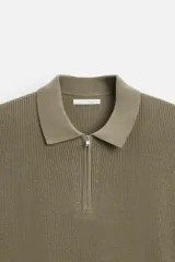 Polo azul marino de punto con cuello solapa y cierre frontal de cremallera. Manga corta y corte regular.