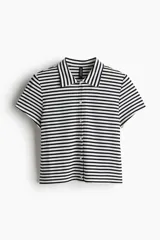 Camisa de manga corta en punto acanalado con rayas horizontales blancas y negras, cuello clásico y botonadura frontal.