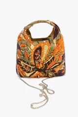 Bolso de mano con cuerpo cubierto de abalorios y bordados multicolores. Tiene asa de mano doble y correa metálica extraíble para usar como bandolera. El cierre es imantado.