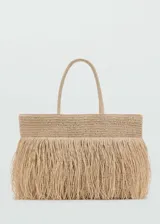 Bolso tipo shopper color beige, tejido en fibra natural con detalle de flecos. Tiene doble asa de mano, cierre con botón magnético y bolsillo interior.