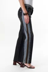 Pantalón de jean azul con paneles en distintos tonos de azul y marrón, corte recto y terminación desflecada.