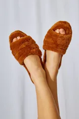 Pantuflas tipo slide forradas en piel sintética 100% poliéster, con base de goma de 4 cm.